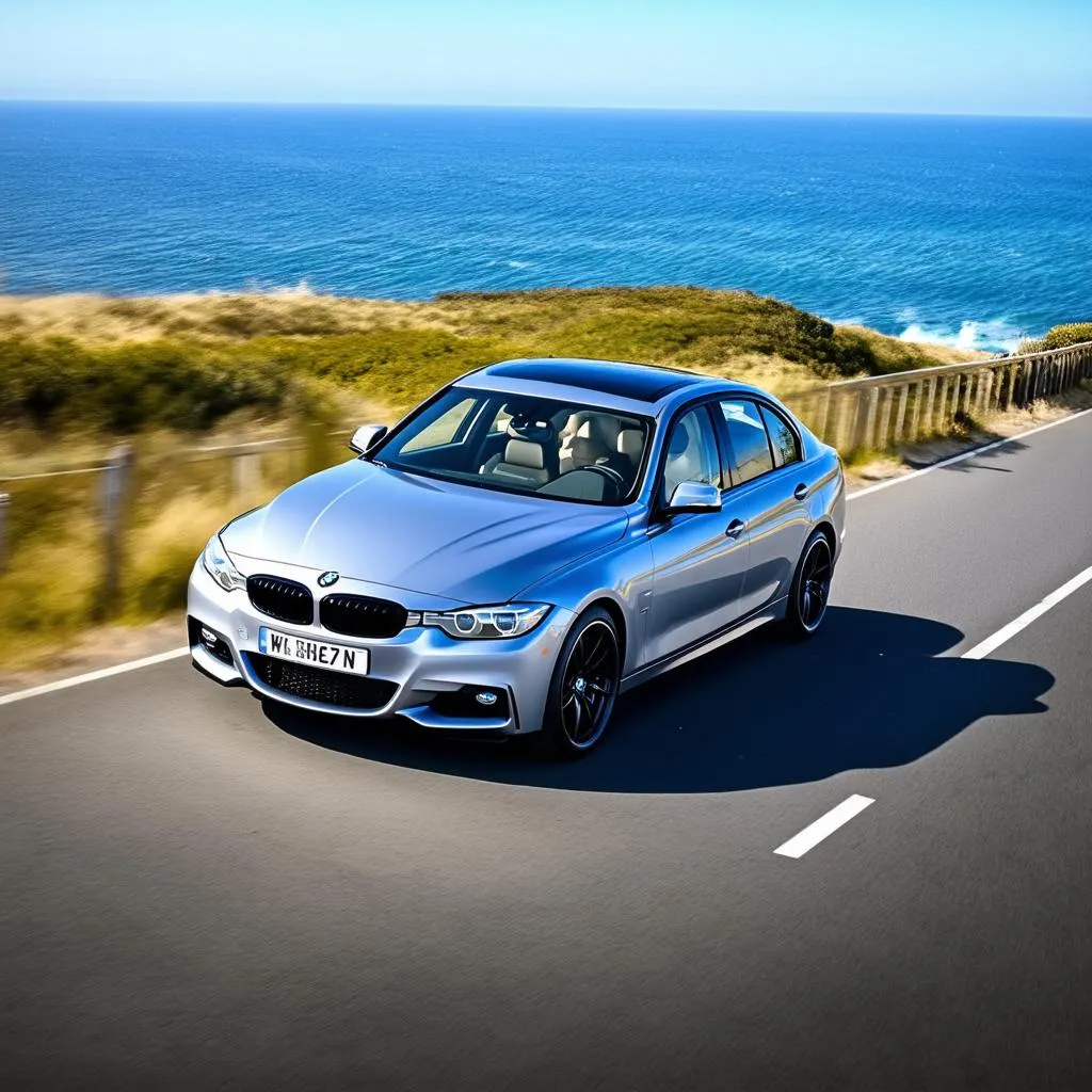 BMW 3 Series with black rims driving down the Pacific Coast Highway