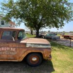 Vintage Ford pickup truck advertising Browne Auto Salvage, indicating arrival at the car parts source in Sunset, Texas.