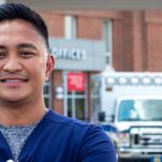 Smiling male nurse standing outside UPMC Muncy hospital showcasing career growth.