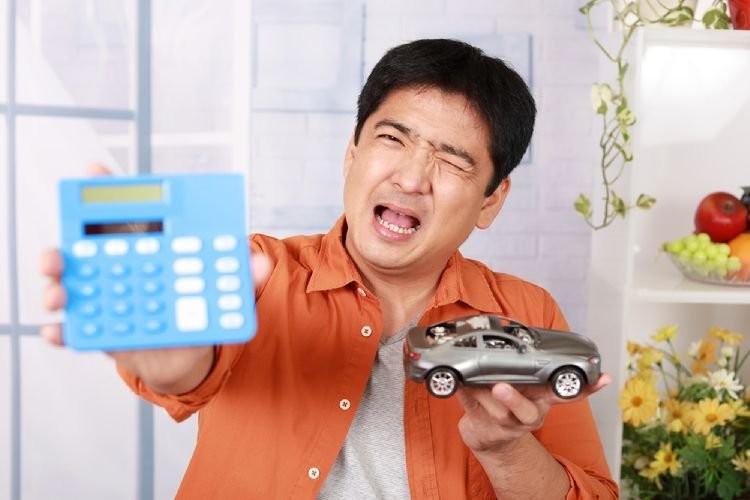 Person Signing Car Loan Documents at Dealership