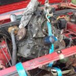 Dismantling an old car to salvage parts for upcycling, a hands-on learning experience.