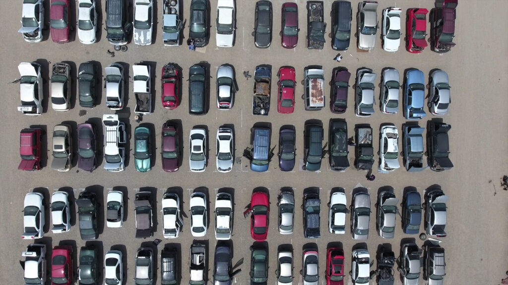 A wide view of the iPull-uPull Fresno junkyard lot filled with rows of cars, showcasing the extensive inventory of used car parts.