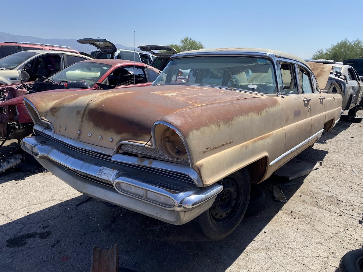 Front view of a 1956 Lincoln Premiere in white and beige, showcasing its iconic grille and headlight design