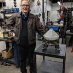 Stephen Uhle, Oregon artist, in his workshop surrounded by car part art materials and finished welded sculptures.