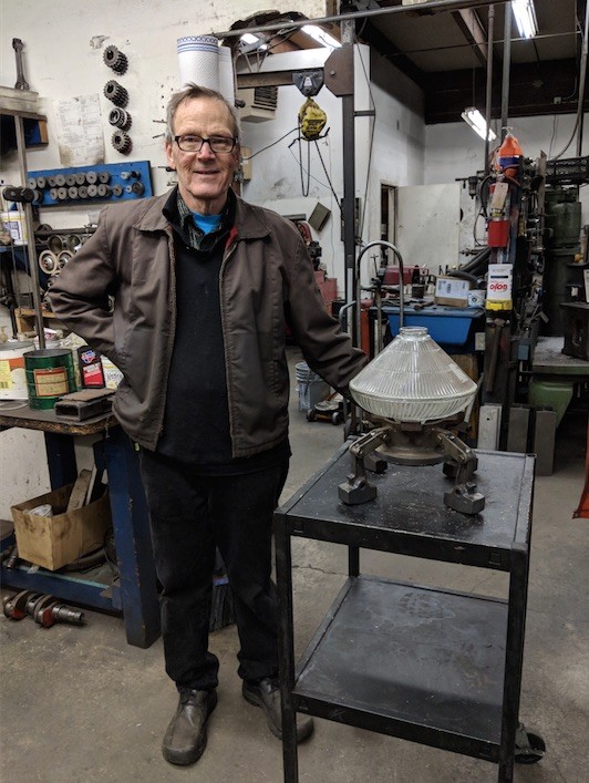 Stephen Uhle, Oregon artist, in his workshop surrounded by car part art materials and finished welded sculptures.