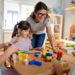 Teacher helping a child at a daycare center