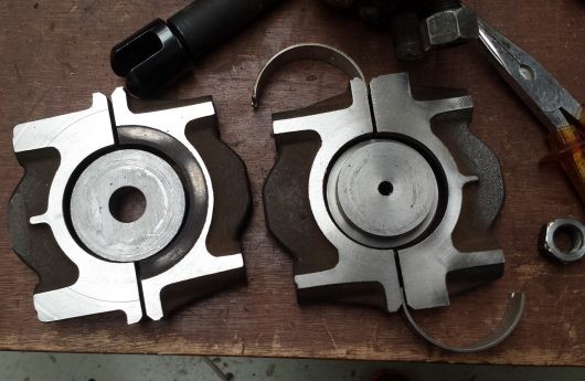 Mild steel pieces welded to crankshaft mounts to create wall mounts for repurposed car part furniture.