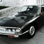 Citroen SM front view parked on a paved area, showcasing its iconic headlights and design.