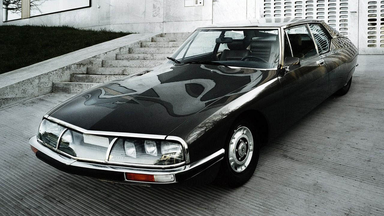 Citroen SM front view parked on a paved area, showcasing its iconic headlights and design.